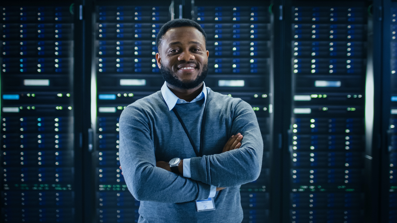 managed service provider - black IT engineer standing in front of servers